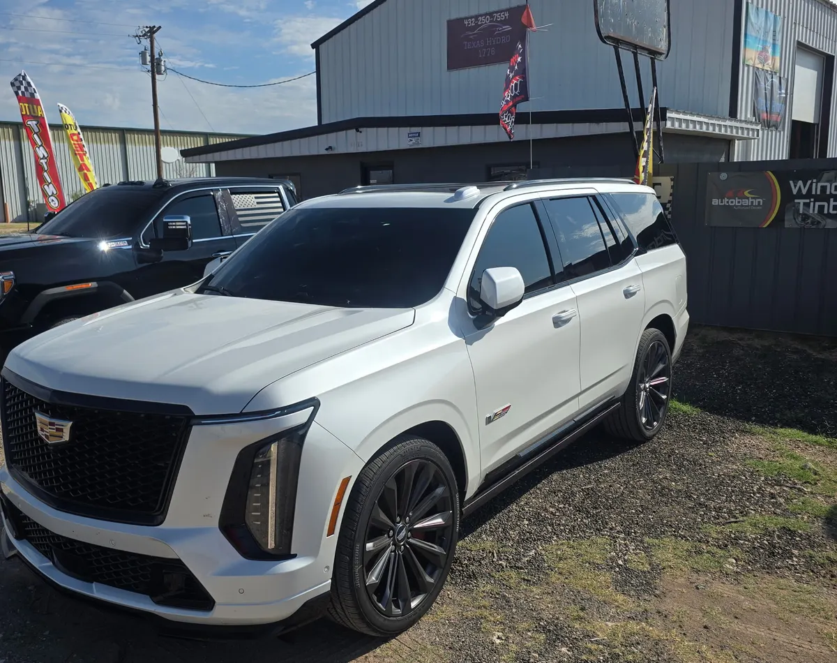 White Cadillac Escalade V with dark tinted glass, parked outside the Texas Hydro DNT shop