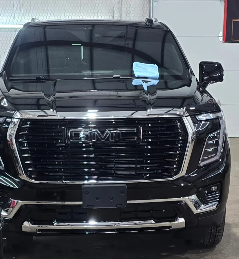 Black GMC Yukon Denali, front on, chrome grille and gloss black paint