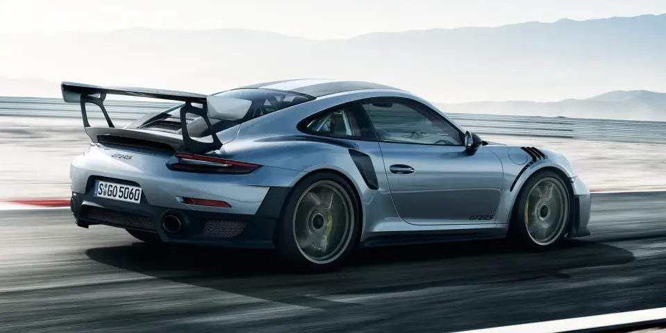 A silver Porsche 911 on a track, the frame divided into vertical bands that step from untinted factory glass on the left to 5% limo tint on the right.